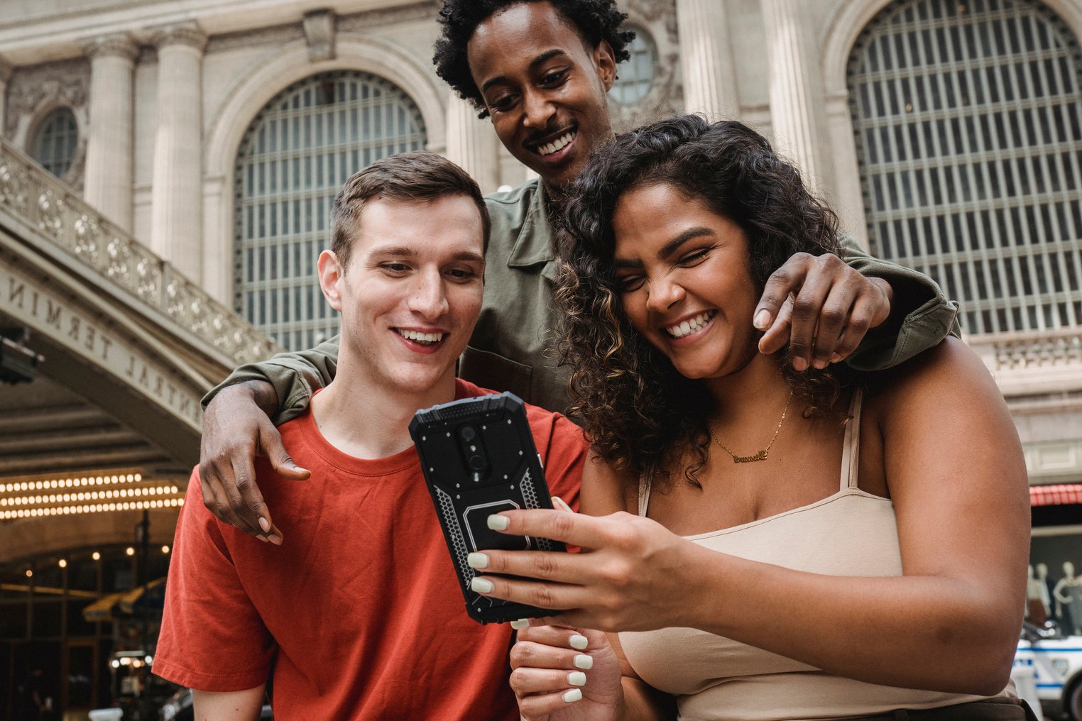 Happy multiethnic friends browsing smartphone